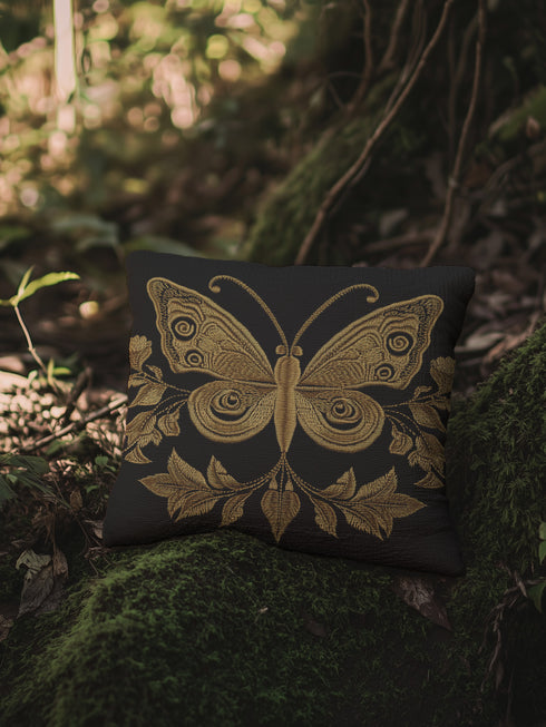 A black woven throw pillow featuring an embroidered gold Hamsa hand surrounded by intricate floral and botanical designs.